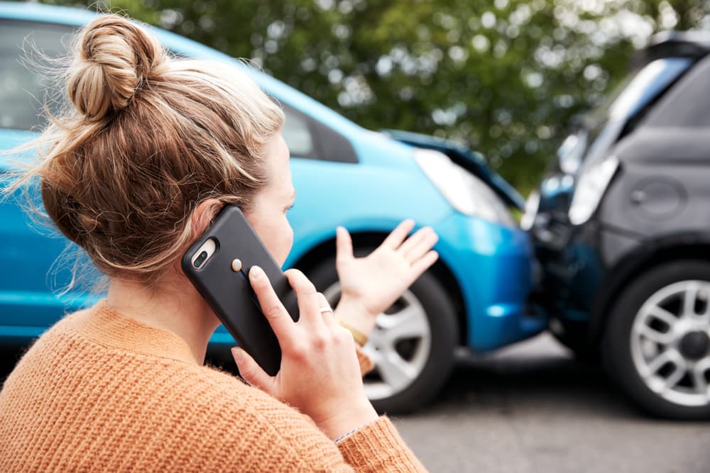 a woman involved in a car accident, making a phone call to her insurance company