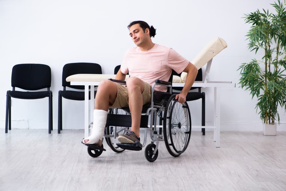 Young disabled man after motorcycle accident patiently waiting for his turn in a hospital hallway.