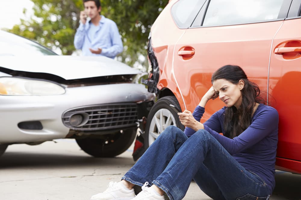 Female driver calling for help after being involved in a traffic accident.