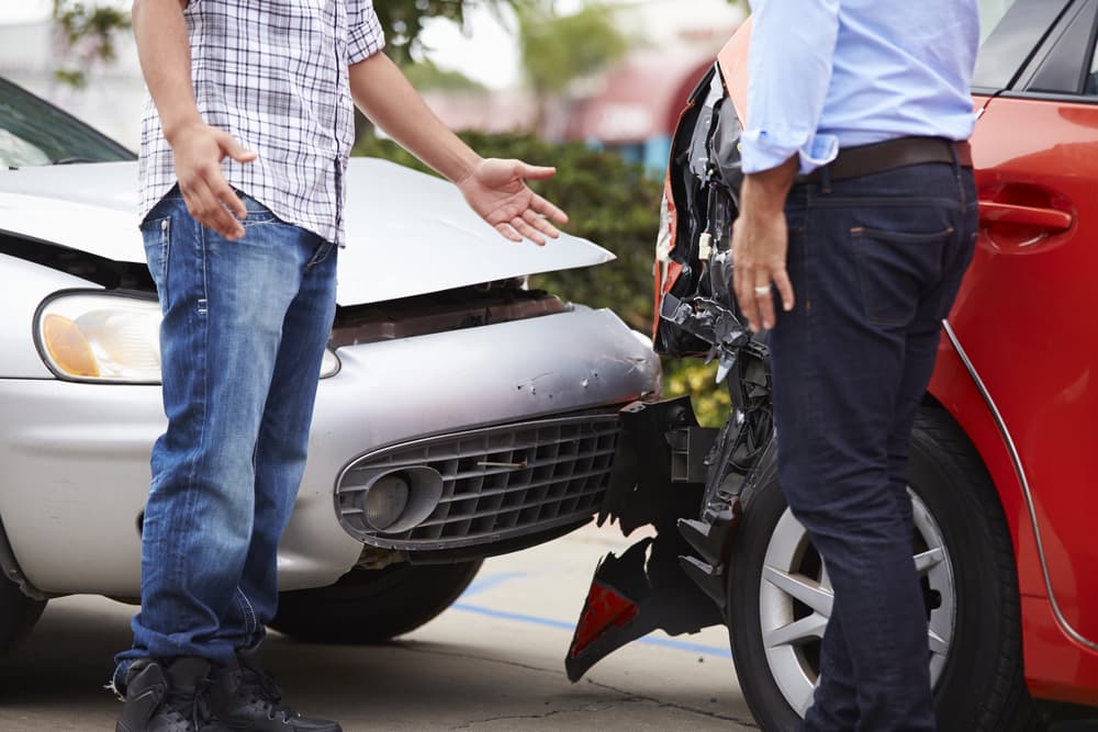 two people arguing after a rear-end car crash