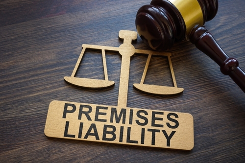 A legal-themed image featuring a wooden sign with the words "Premises Liability" next to a gavel, symbolizing legal responsibility and justice.