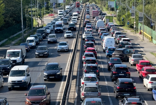 Aerial view of heavy traffic congestion on a multi-lane road, with cars closely packed together, indicating rush hour or a traffic jam.