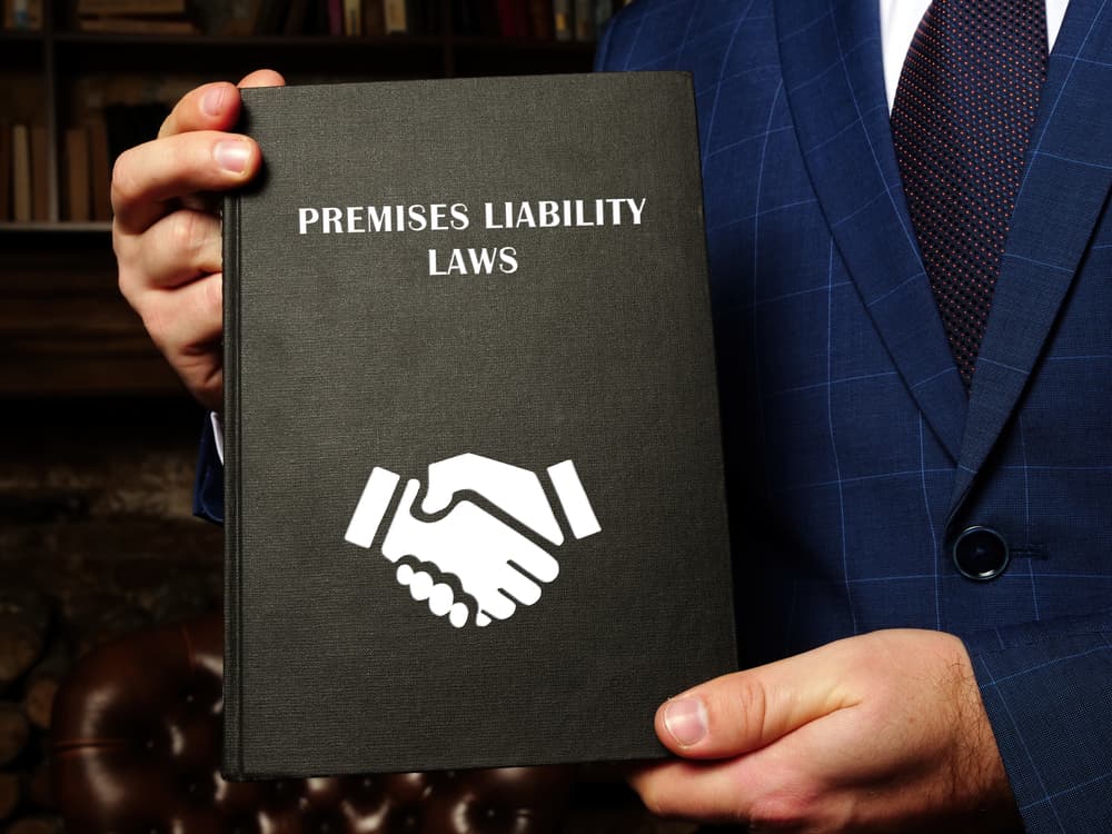 Lawyer holds PREMISES LIABILITY LAWS book.