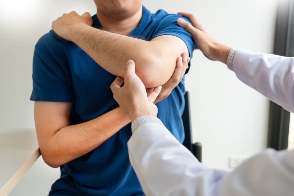 Doctor and patient suffering or Chiropractor examining from shoulder pain in clinic