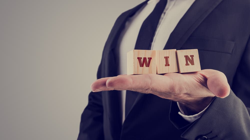 A lawyer holding wooden alphabet blocks reading - Win