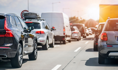 Heavy traffic of cars and SUVs on a busy highway during daylight.