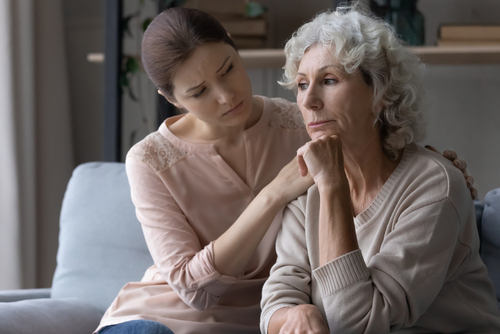 A younger woman comforting an older woman who appears sad, symbolizing grief and emotional support after a wrongful death.