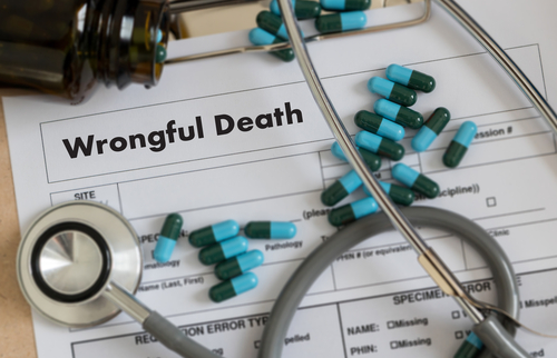 Close-up of a wrongful death document with pills and a stethoscope on top.