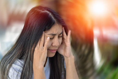 Traumatic Brain Injury Claim Florida attorney represented through an image of a woman holding her head in pain as dizziness and blurred vision signal possible TBI symptoms.
