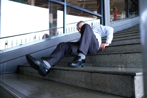 A man lying on a staircase after a fall, illustrating injuries handled by a Daytona slip and fall accident lawyer.
