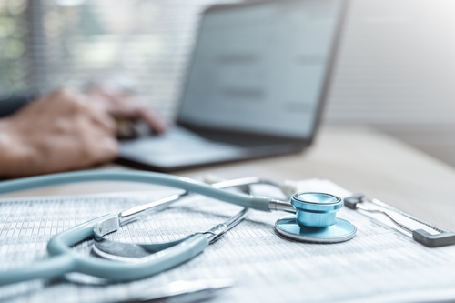 A stethoscope on medical paperwork near a laptop, symbolizing the medical evidence used in claims handled by a Gainesville brain injury lawyer.