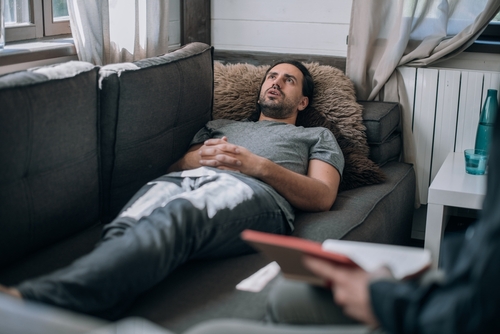 Man lying on couch during evaluation for cognitive symptoms after head trauma, representing a case handled by an Ocala traumatic brain injury lawyer.