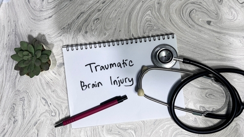 Notepad labeled traumatic brain injury with stethoscope on desk, symbolizing legal guidance from an Ocala traumatic brain injury lawyer.