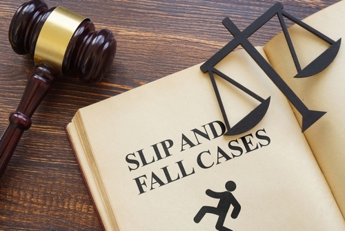 Law book labeled slip and fall cases with gavel and scales of justice, symbolizing legal representation by a Gainesville Slip and Fall Accident Lawyer.