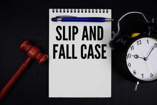 Notepad labeled slip and fall case beside gavel and clock, symbolizing legal action with a Gainesville slip and fall accident lawyer.
