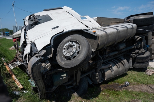 Jackknife truck accidents in Gainesville with an overturned semi-truck lying on its side after a crash.