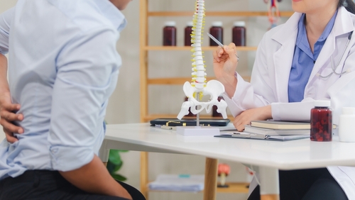 Gainesville truck accident lawyer consulting with an injured patient about spinal injuries after a crash.