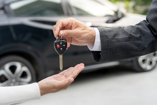 Gainesville car accident involving rental or rideshare drivers showing a person handing over car keys during a rental transaction.