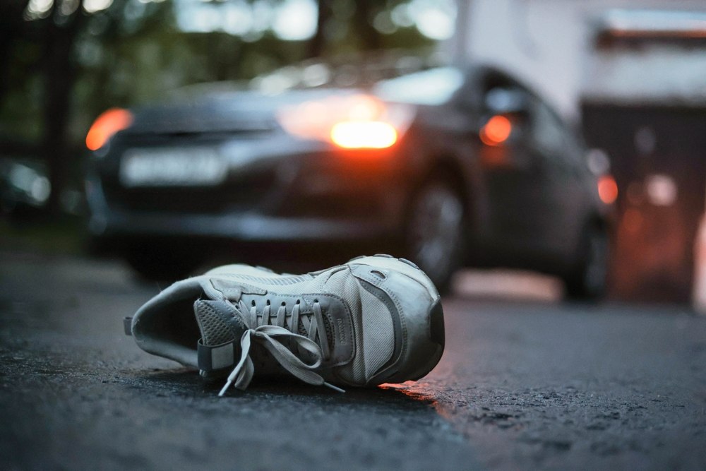 Shoe left on the pavement near a car at dusk after a pedestrian accident in Duckpond Gainesville