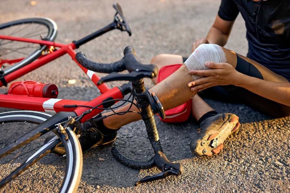 Injured cyclist wrapping their knee after a bicycle accident near UF and Butler Plaza