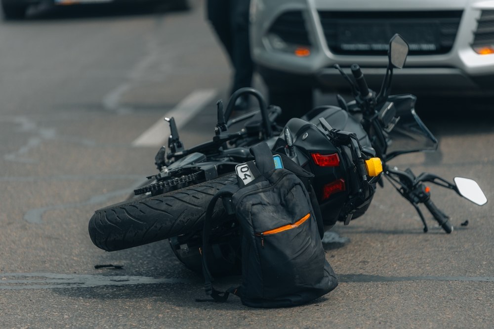 Damaged motorcycle and rider's gear on the road, important motorcycle accident evidence for a compensation claim