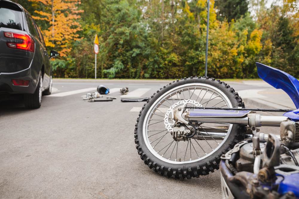 Motorcycle wheel and scattered gear at an intersection, key evidence in a motorcycle accident fault investigation