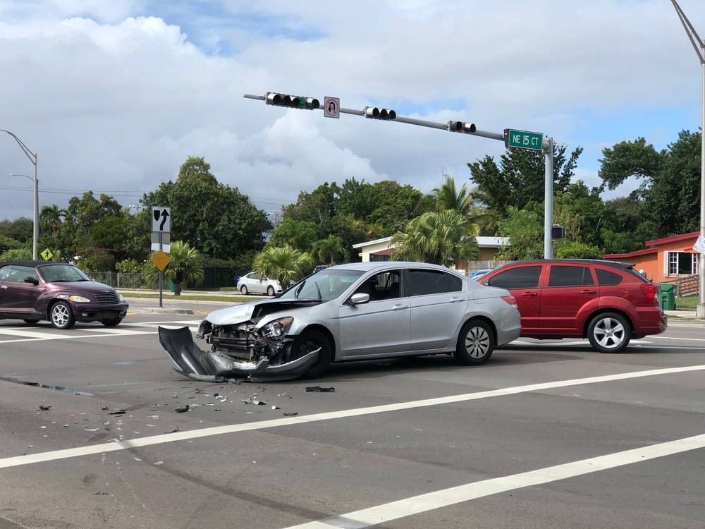 Silver sedan with front-end damage after a car accident at a Gainesville intersection